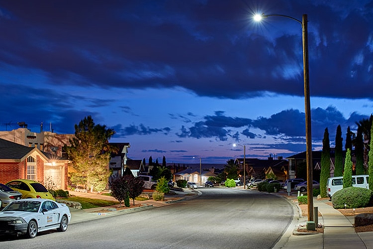 Residential street illuminated by Autobahn cobra heads at night.